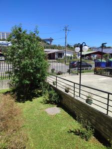 a fence with a tree and a street light at Privado y Acogedor in Puerto Montt