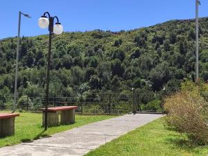 two benches and a street light with a mountain in the background at Privado y Acogedor in Puerto Montt