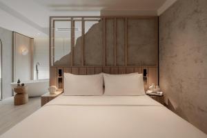 ein Schlafzimmer mit einem großen Bett und weißen Kissen in der Unterkunft The Cara Hotel in Kota Kinabalu