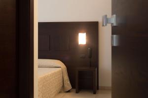 a bedroom with a bed and a light on the wall at Hotel I Crespi in Grosseto