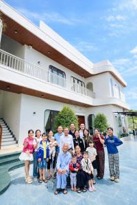 een grote groep mensen die poseert voor een huis bij The Moon's House in Mộc Châu