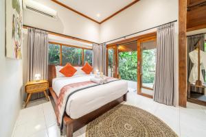 a bedroom with a bed and a large window at Bali Dream Garden - Tropical Escape with Pool & Spa in Ubud