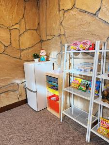 een koelkast en planken in een kamer met een stenen muur bij 雪场缆车站旁-START HOUSE PIAA-Ski IN Ski OUT in Minami Uonuma