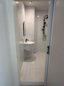 een witte badkamer met een wastafel en een douche bij Three Monkeys Chaweng Beach in Nathon Bay