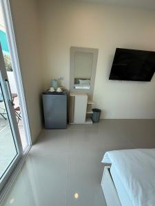 een kamer met een bed, een spiegel en een tafel bij Three Monkeys Chaweng Beach in Nathon Bay