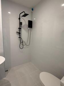 een witte badkamer met douche en toilet bij Three Monkeys Chaweng Beach in Nathon Bay