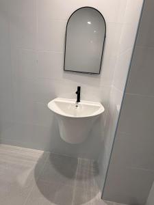 een badkamer met een witte wastafel en een spiegel bij Three Monkeys Chaweng Beach in Nathon Bay +4 foto's