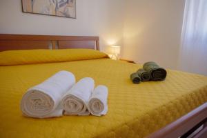 Salerno Airport - Aeroporto di SalernoTree home的一张床上放着两条卷起的毛巾和两台摄像机。 更多20张照片