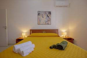 Salerno Airport - Aeroporto di SalernoTree home的一间卧室配有黄色的床和毛巾