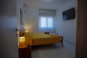 Salerno Airport - Aeroporto di SalernoTree home的一间卧室配有黄色的床和电视