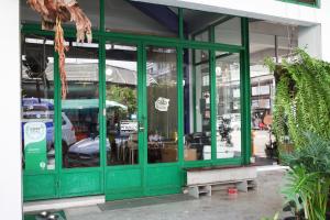 een groene winkelpui met een bankje ervoor bij The Urbanists BKK Entire Floor 4-6 people 4Beds 4Baths near Medpark Hospital , Queen Sirikit Convention hall , Benjakitti Park in Bangkok