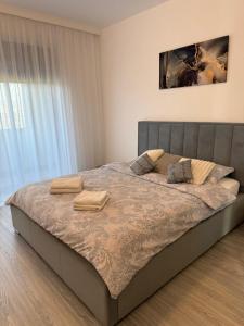 ein Schlafzimmer mit einem Bett, auf dem zwei Handtücher liegen in der Unterkunft Malvina Apartments Cazare Mures in Târgu Mureș