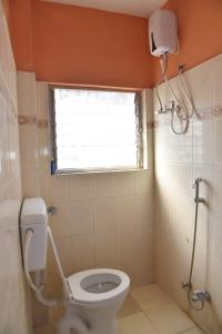 un piccolo bagno con servizi igienici e finestra di Samarth Villa a Akalkot