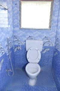 bagno blu con servizi igienici e finestra di Samarth Villa a Akalkot