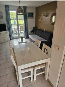 een keuken en woonkamer met een tafel en stoelen bij La Cabre d'Or - Duplex avec piscine partagée in Cabriès