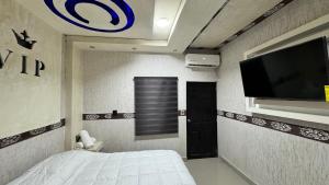 a bedroom with a bed and a flat screen tv at Hotel VIP in Tequesquitengo