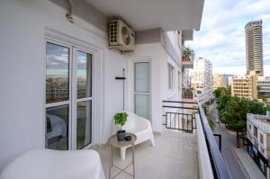 a white apartment balcony with a plant on it at Mnasiadou Suite 16 in Nicosia