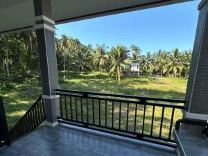 een balkon met uitzicht op een gazon en palmbomen bij Hill View Home 3 in Ko Pha Ngan