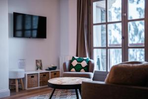 a living room with a couch and a chair and a window at Le Refuge d'Elyze in Arc 1950