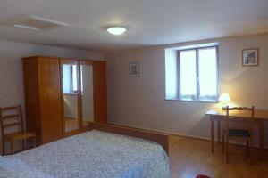 een slaapkamer met een bed, een bureau en een raam bij Grain d'orge in Aubepierre-sur-Aube