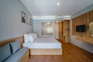 ein Hotelzimmer mit einem Bett und einer Couch in der Unterkunft The Rooms Apartment Bali by ARM Hospitality in Denpasar