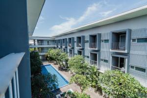 eine Luftansicht eines Apartmentgebäudes mit einem Pool in der Unterkunft The Rooms Apartment Bali by ARM Hospitality in Denpasar