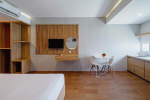 ein Schlafzimmer mit einem Bett und einem Tisch mit Stühlen in der Unterkunft The Rooms Apartment Bali by ARM Hospitality in Denpasar + 56 Fotos