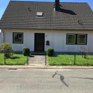 a white house with a black roof and a driveway at Alexander´s Ferienwohnungen in Gerlingen