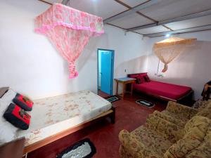 een woonkamer met een bed en een bank bij Little House Inn Anuradhapura in Anuradhapura