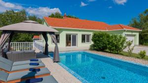 een villa met zwembad en parasol bij Villa FourM - Makarska by Villas Guide in Novak