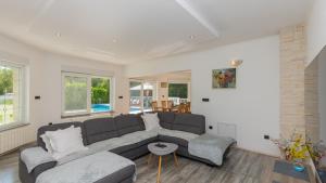 een woonkamer met een bank en een tafel bij Villa FourM - Makarska by Villas Guide in Novak