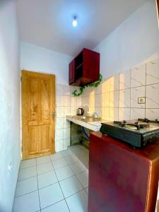 a kitchen with a stove and a wooden door at Monmeublé 237 in Douala +10 photos