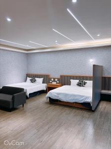a hotel room with two beds and a couch at 夏日微醺二館 in Hengchun South Gate