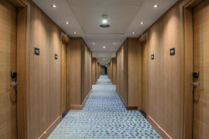 a corridor of a hotel hallway with wooden walls and a tile floor at Hilton Geneva Hotel and Conference Centre in Geneva