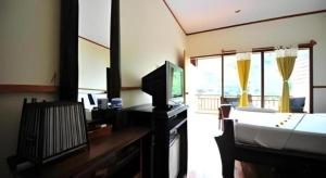 a hotel room with a bed and a tv and a room at Phuttachot Resort in Phi Phi Don +98 photos