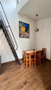 a dining room with a table and chairs and a staircase at Casa Margarita in Pátzcuaro