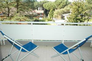 2 Stühle auf einem Balkon mit Aussicht in der Unterkunft Appartamenti Meridiana in Lignano Sabbiadoro