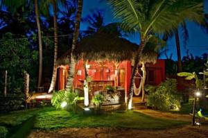 una casa roja con palmeras y luces en Pousada Rio Verde Ltda, en Icaraí