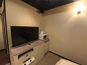 a room with a flat screen television and a microwave at ヴァンヴェールアネックス in Kyoto