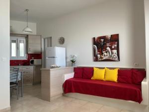 een woonkamer met een rode en gele bank in een keuken bij Solid Residence in Triovasálos +32 foto's