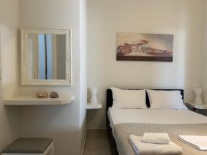 een witte slaapkamer met een bed en een spiegel bij Solid Residence in Triovasálos