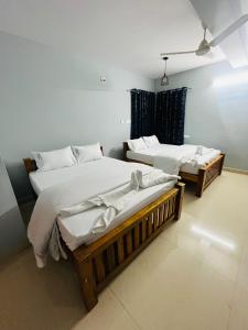 deux lits jumeaux dans une chambre avec fenêtre dans l'établissement Coastal Nest Home - Malpe Beach, à Malpe