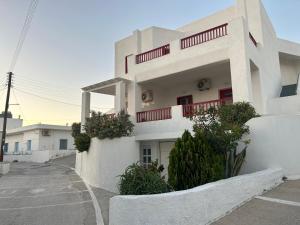 a white building with red balconies on a street at Solid Residence in Triovasálos +31 photos