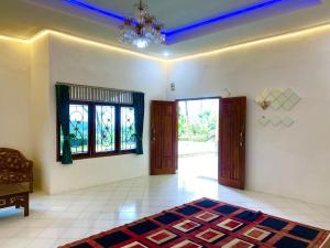 Ein Wohnzimmer mit Kronleuchter, Türen und einem Teppich in der Unterkunft New Villa Privat Pool 5 Kamr in Sampal 2