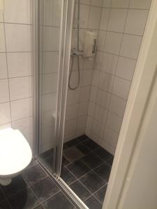 La salle de bains est pourvue d'une douche avec une porte en verre. dans l'établissement Nordfjord Hotell - Bryggen, à Nordfjordeid