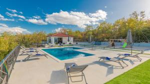 una piscina con sedie e un parco giochi di Villa Lea-Makarska by Villas Guide a Grubine