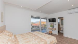 una camera da letto bianca con un letto e un balcone di Villa Lea-Makarska by Villas Guide a Grubine Altre 45 foto