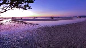- une vue sur la plage et le coucher du soleil dans l'établissement Lorna's Home, à Bil-isan