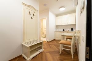 eine Küche mit weißen Schränken, einem Tisch und einem Stuhl in der Unterkunft Casa Doseanu in Oradea