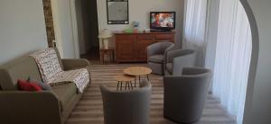 een woonkamer met een bank, stoelen en een tafel bij Villa jeandor in Braucourt